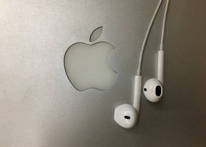 Fone de ouvido Iphone sobre logo Apple.